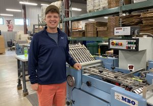 Ben Hamaker standing in our production center at an MBO folder.