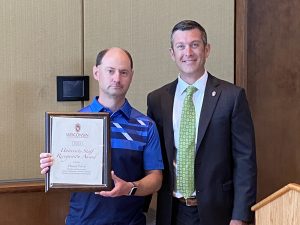 Dan Eberle receiving an award from Patrick Sheehan at UW-Madison