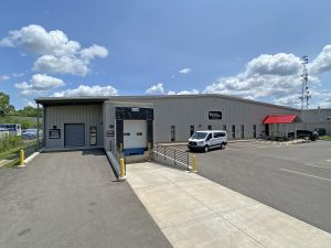 DPPS building exterior in July 2023 with clouds in a blue sky and a delivery van parked in front.