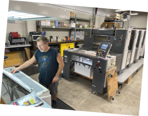 Ron Swenson running the four-color press at DPPS' production center.