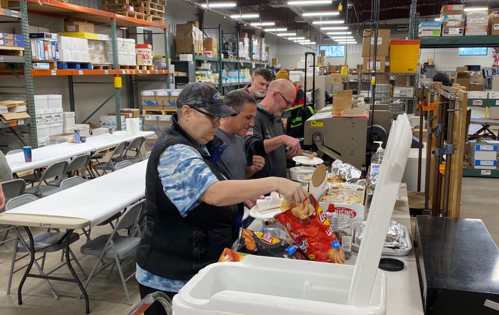 Employees get plates of food ready at the DPPS production center. 