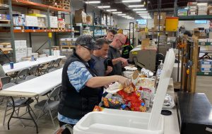 Employees get plates of food ready at the DPPS production center.