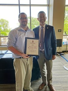 Chris Komorowski receiving his USRA award from chief human resources officer Patrick Sheehan at a ceremony in DeJope Hall June 4, 2024.