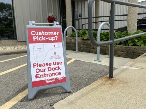 Customer Pickup Sandwich Board standing at front entrance of DPPS