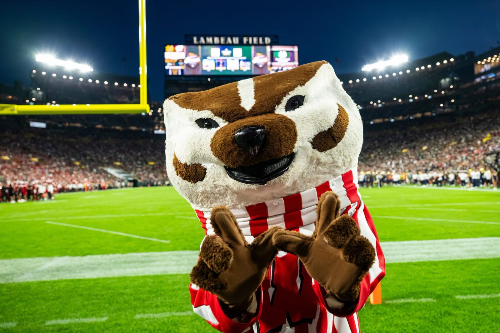 Bucky Badger doing the W sign with his hands at Lambeau Field.